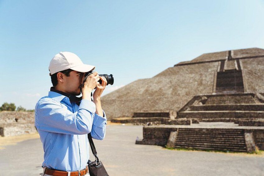 Eine Person fotografiert eine große, pyramidenartige Struktur. 4