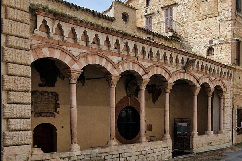 A historic stone building with arched windows and a tiled roof. 3