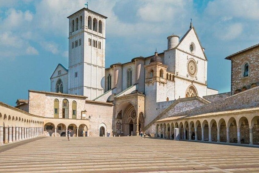 A historic building with a prominent tower, arched walkways, and a large open courtyard. 4