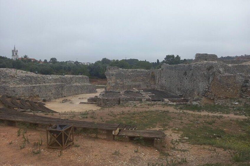 Ancient ruins with stone structures and a wooden viewing platform. 3
