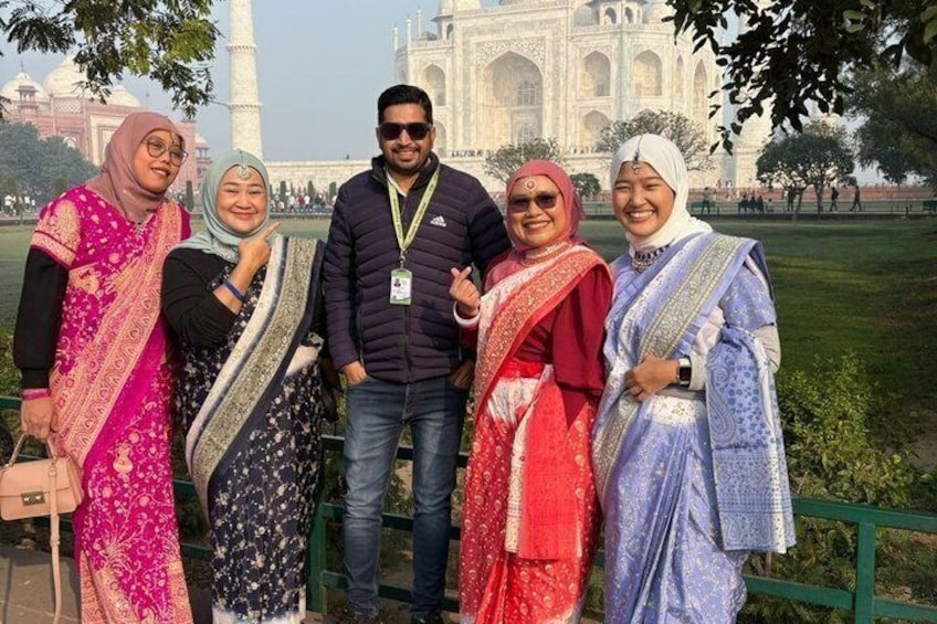 A group of people standing in front of the Taj Mahal. 4