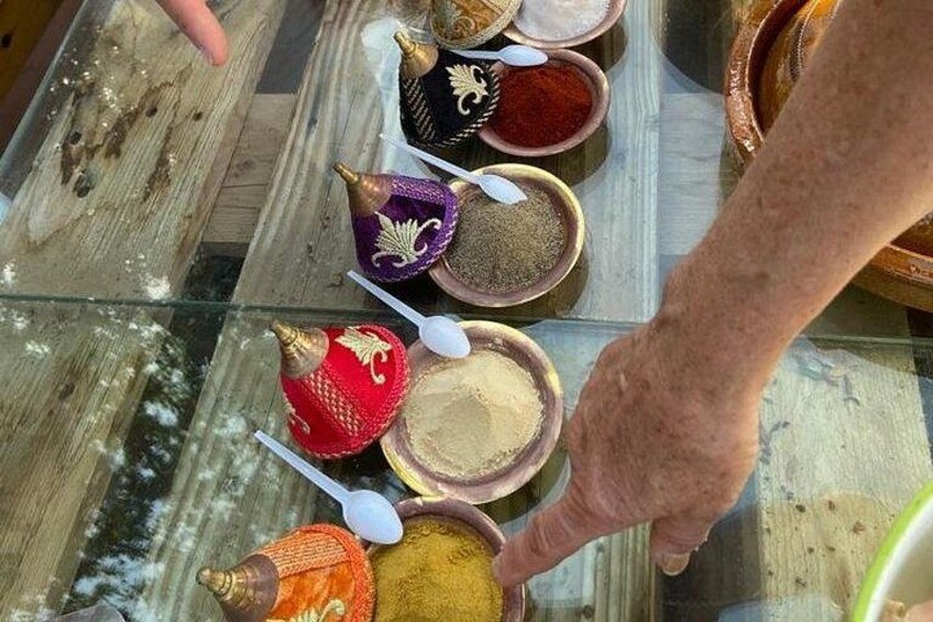 Een hand die een lepel vasthoudt boven een pot met kruiden. 5