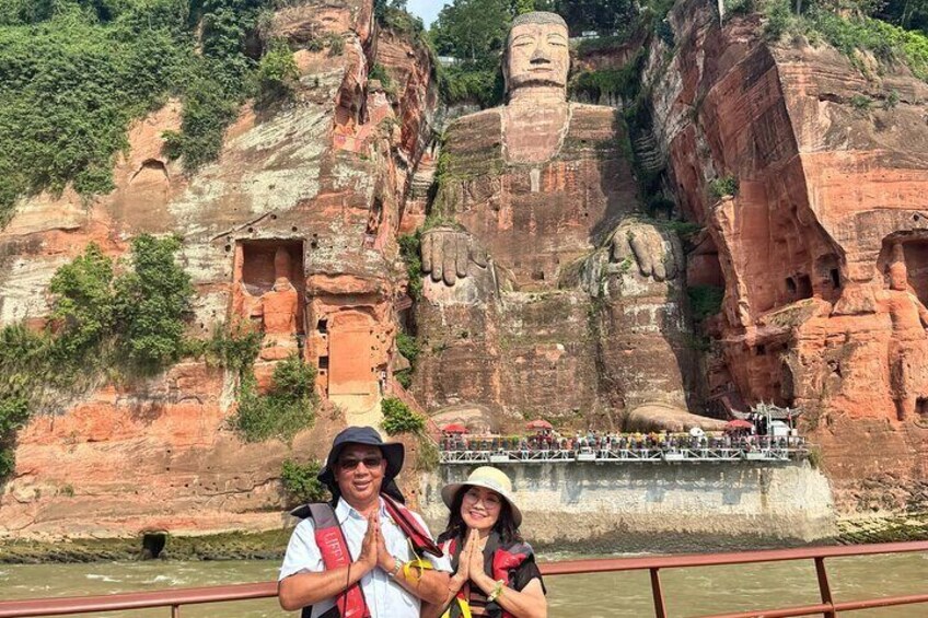 A large Buddha statue on a cliff, a smaller Buddha statue in a cave, and a bridge with people. 2
