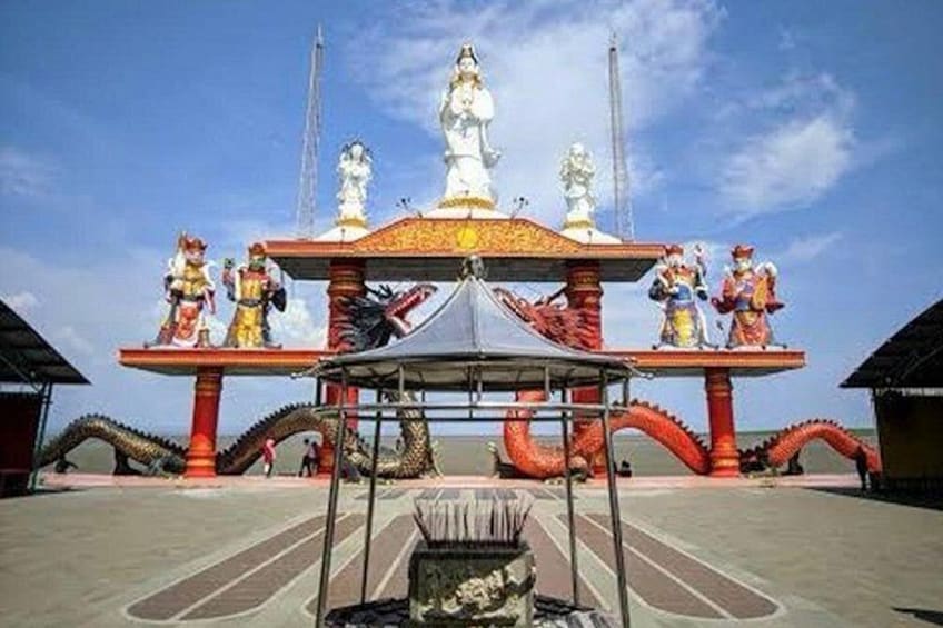 A temple with a central statue, red and gold decorations, and a dragon-like structure. 3
