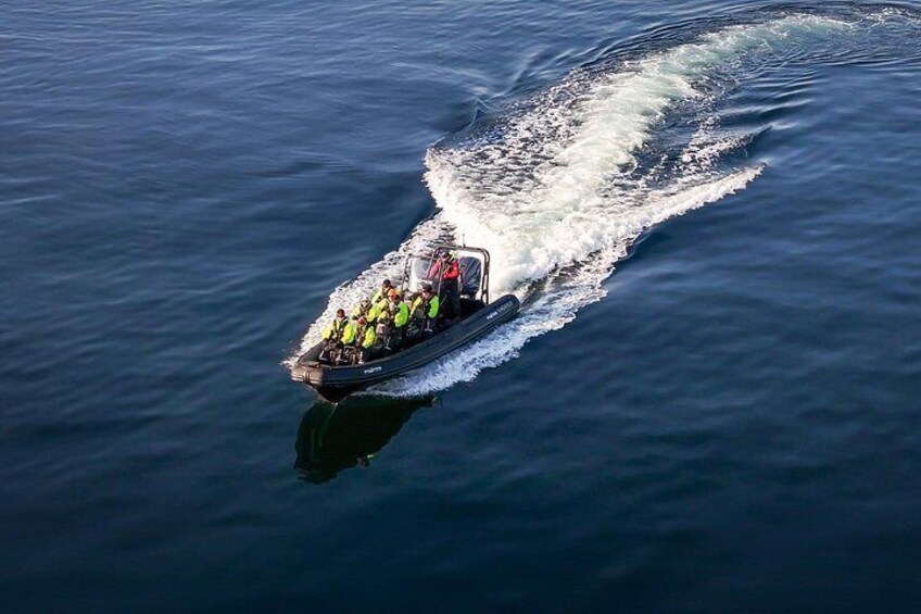 A speedboat with passengers in a body of water. 3
