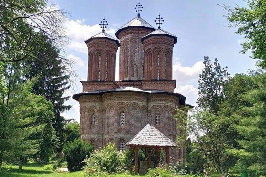 Una iglesia de ladrillo con tres cúpulas y una edificación más pequeña al frente. 4