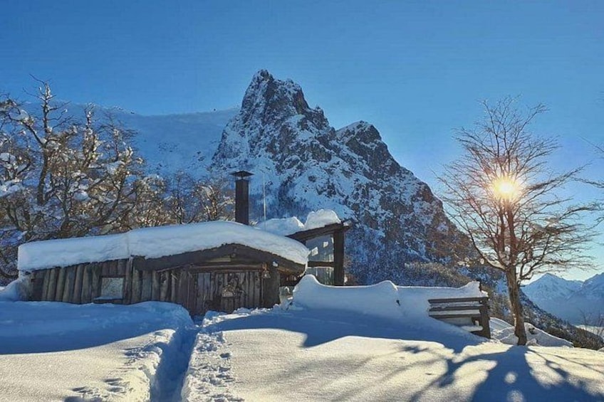 A snow-covered mountain, a wooden cabin, and a clear sky. 3