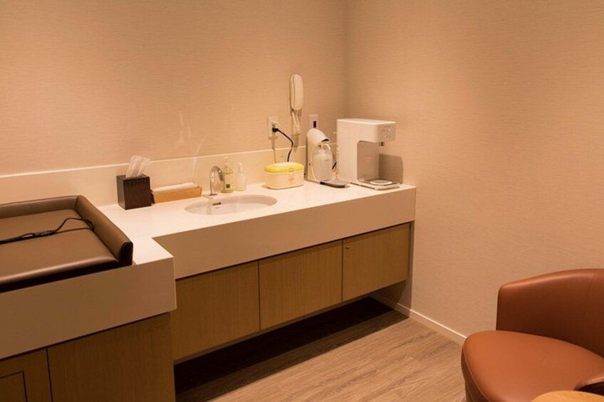Un bagno moderno con lavandino, specchio e macchina da caffè. 5