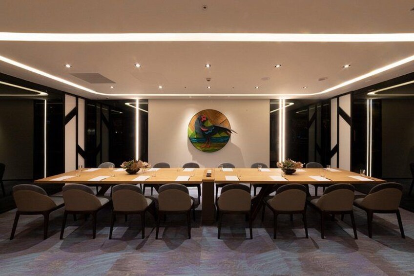 Una sala conferenze con un lungo tavolo, sedie e un quadro colorato appeso al muro. 3