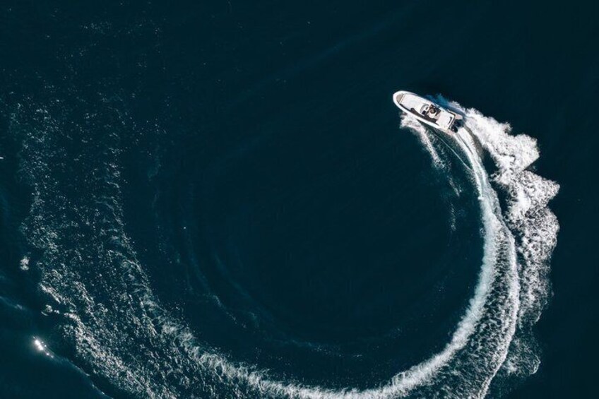 A boat creating a circular wake in the ocean. 1