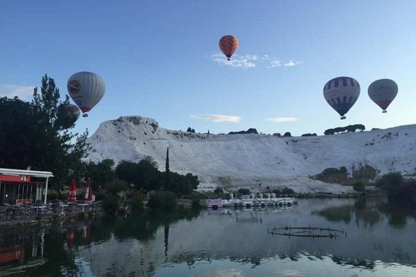 Heenliftballonnen, een meer en een heuvel met een gebouw. 5