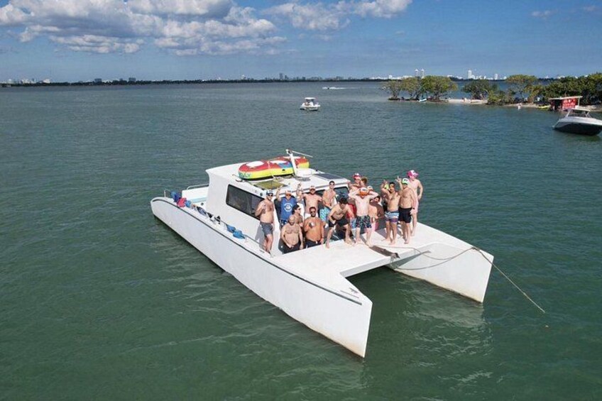 Ein weißes Boot mit Personen liegt in ruhigem Wasser unter einem klaren Himmel festgemacht. 2