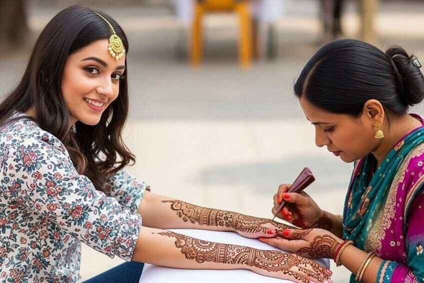 Two women applying henna on each other's hands. 4