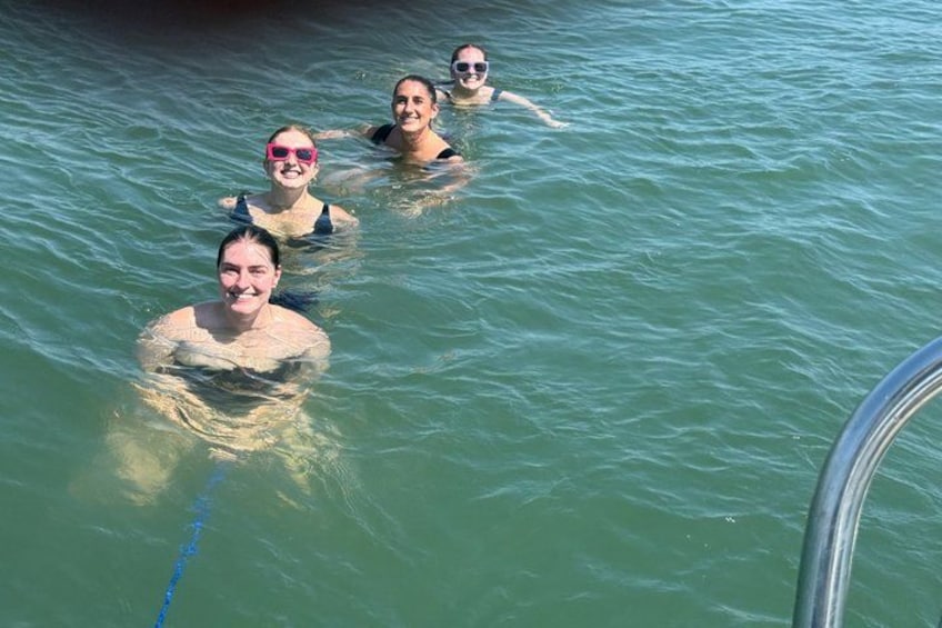 Three people swimming in a pool. 5