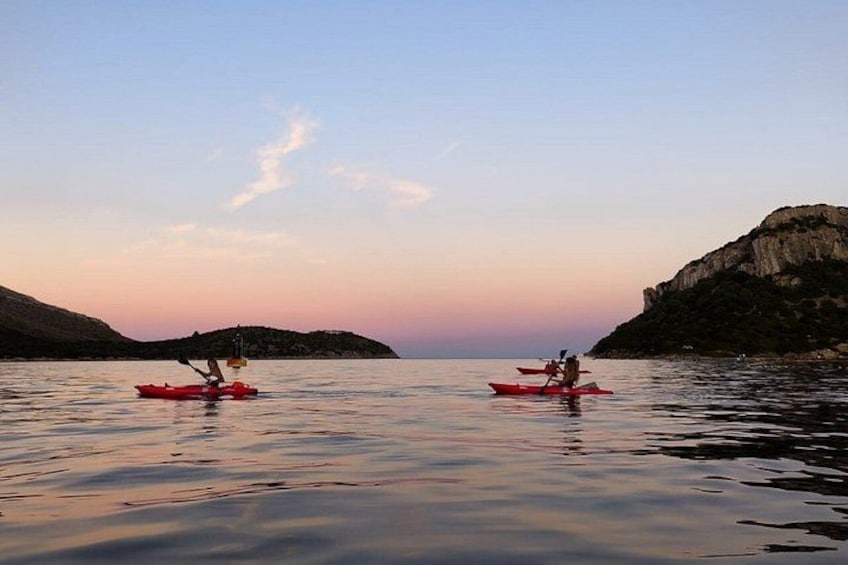 Deux kayaks sur une étendue d’eau calme, avec une côte rocheuse et un ciel dégagé. 5