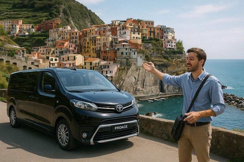 A black van parked on a coastal road with a man gesturing towards a scenic coastal village. 1