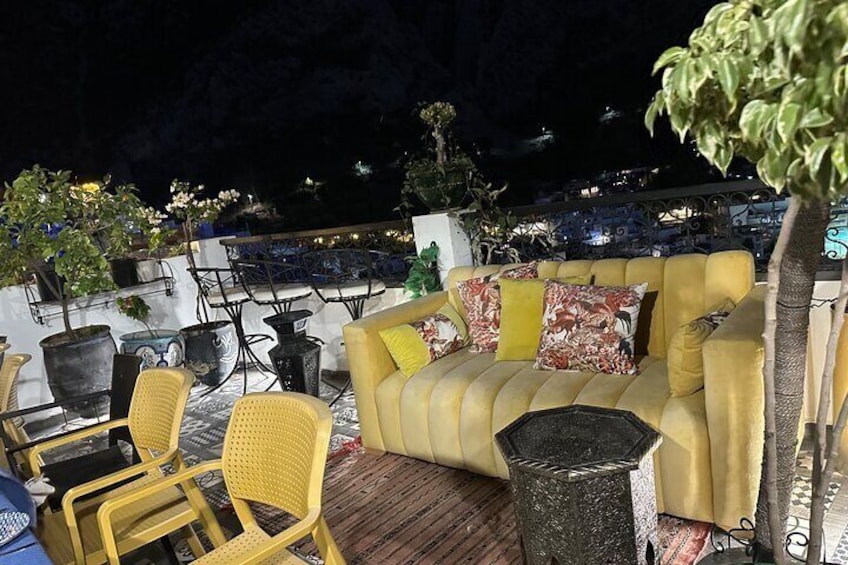 A cozy outdoor seating area with yellow chairs and a sofa with colorful cushions. 1