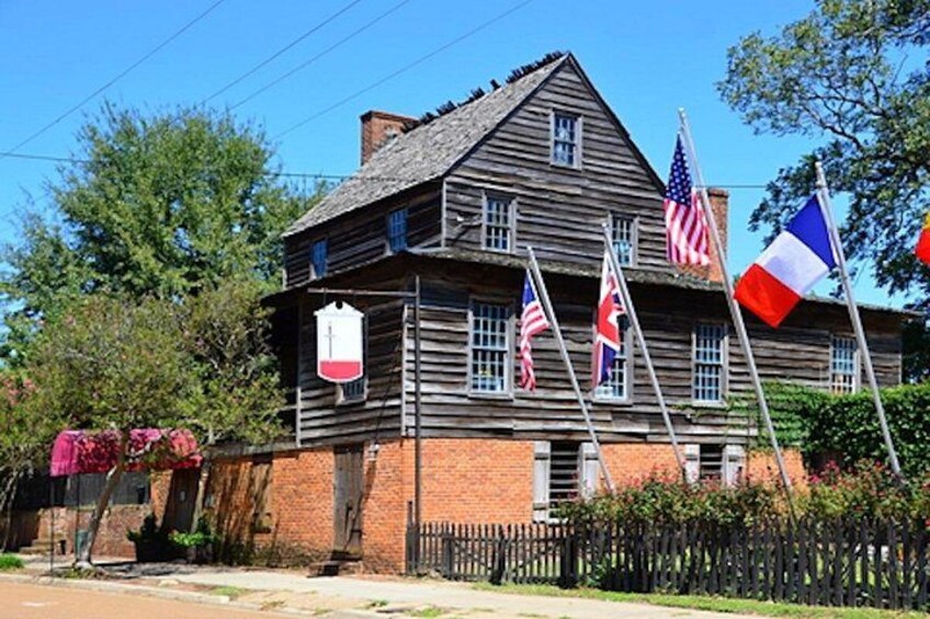 A wooden house with multiple flags, including the American flag, French flag, and others. 3