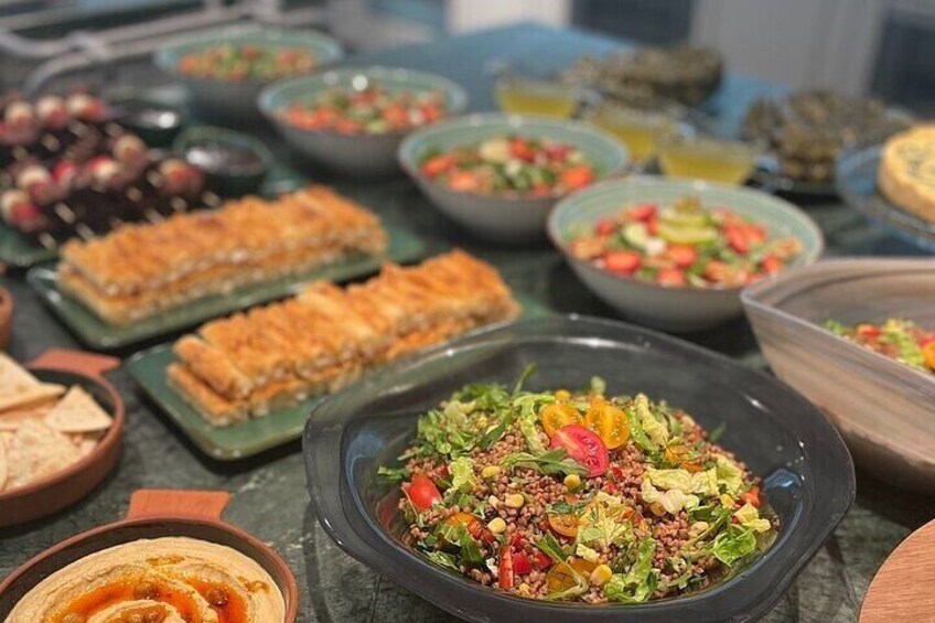 Variedad de platos con ensaladas, pan y salsas sobre una mesa. 2
