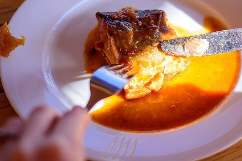 Un trozo de carne siendo cortado con un cuchillo y un tenedor sobre un plato blanco. 4