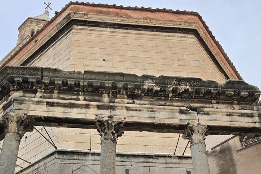 Un bâtiment historique doté de colonnes de style classique et d’un cornisement finement travaillé. 1