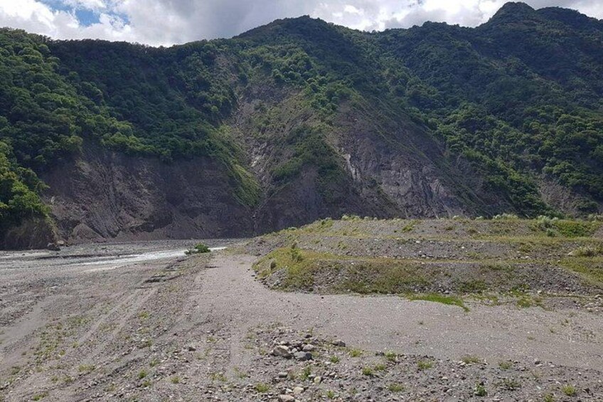 A river flowing through a mountainous landscape with rocky terrain and sparse vegetation. 2