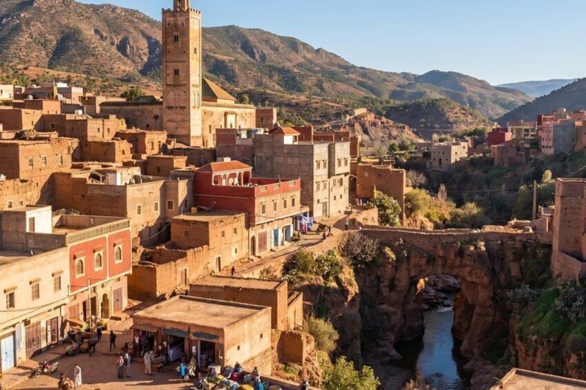 A historic town with a prominent tower, narrow streets, and a river. 4