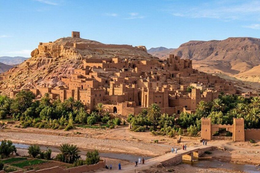 A desert town with adobe buildings, palm trees, and a river. 3