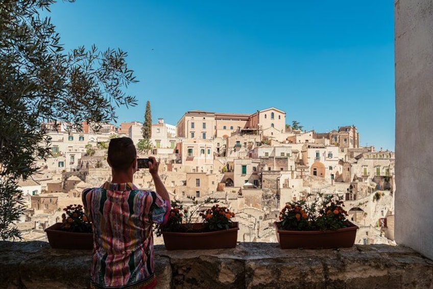 En person fotograferar en historisk stad med byggnader som har fasader av terrakotta. 2