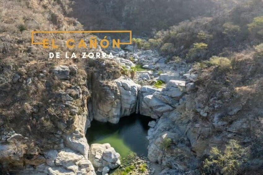 A canyon with a narrow passage and a small pool of water. 2