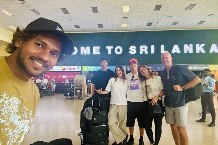 A group of people in an airport with a sign that reads 'WELCOME TO SRI LANKA' in the background. 4