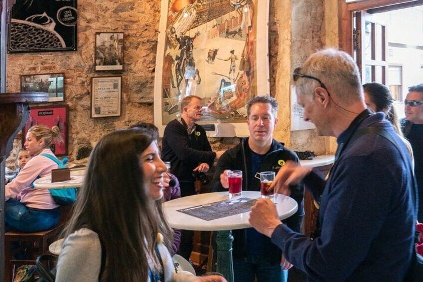 A group of people in a restaurant with stone walls and artwork. 5