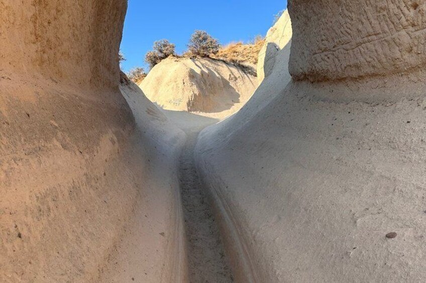 Un canyon stretto con pareti ripide e vegetazione rada. 2