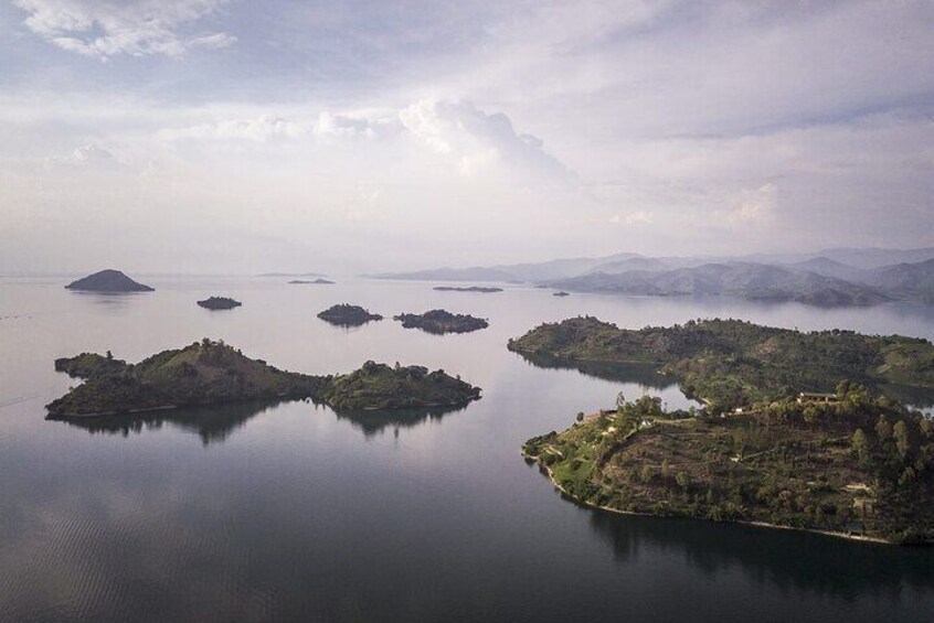 Un lac paisible, parsemé de plusieurs petites îles et abritant une plus grande île où se trouvent des bâtiments. 2