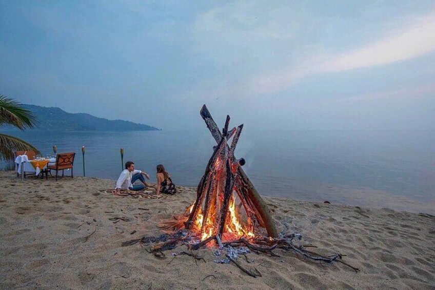 Un feu de camp sur une plage, avec des personnes assises à proximité. 1