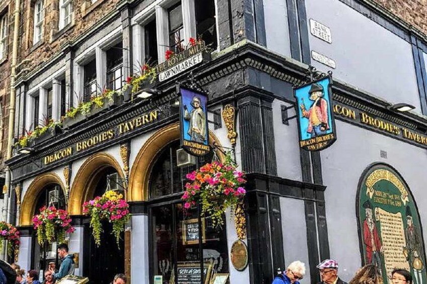 The exterior of Deacon Brodie's Tavern with flower baskets and banners. 2