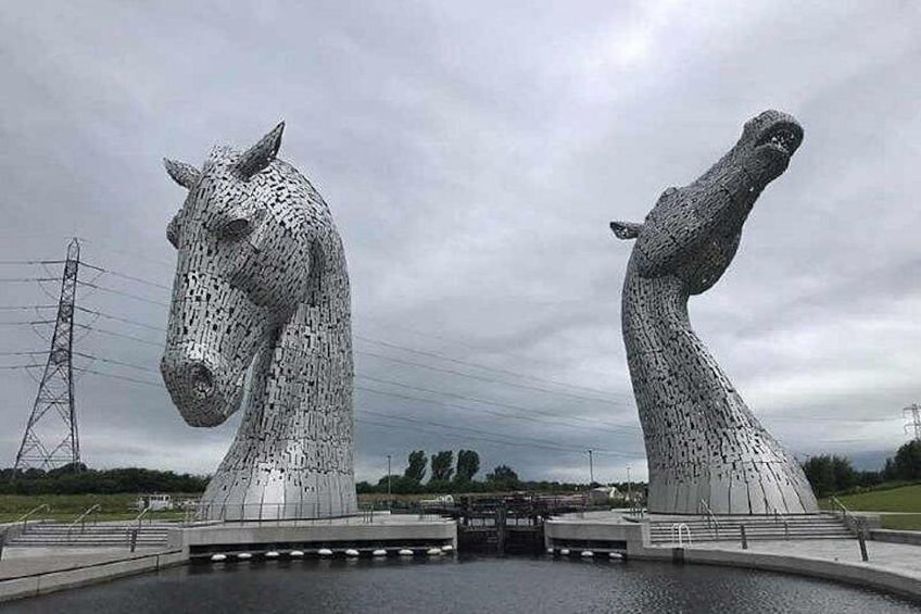 Two large horse sculptures, a bridge, and a body of water. 1