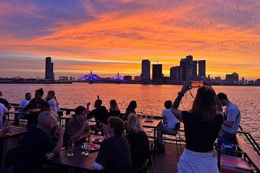 A sunset over a body of water with a city skyline in the background. 3