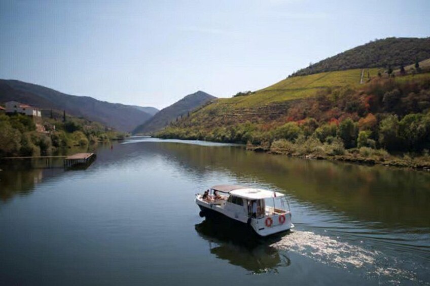 A boat on a calm river surrounded by hills. 1