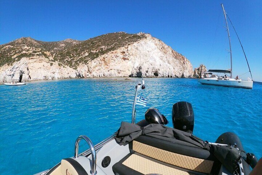 A boat with a rocky coastline and a sailboat in the background. 5