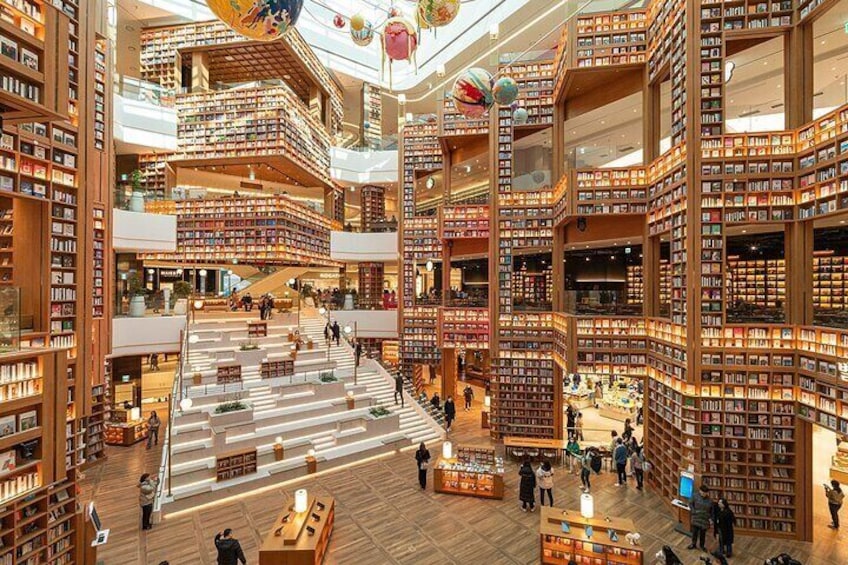 Una librería de varios niveles con estanterías de madera y un espacio central abierto. 5