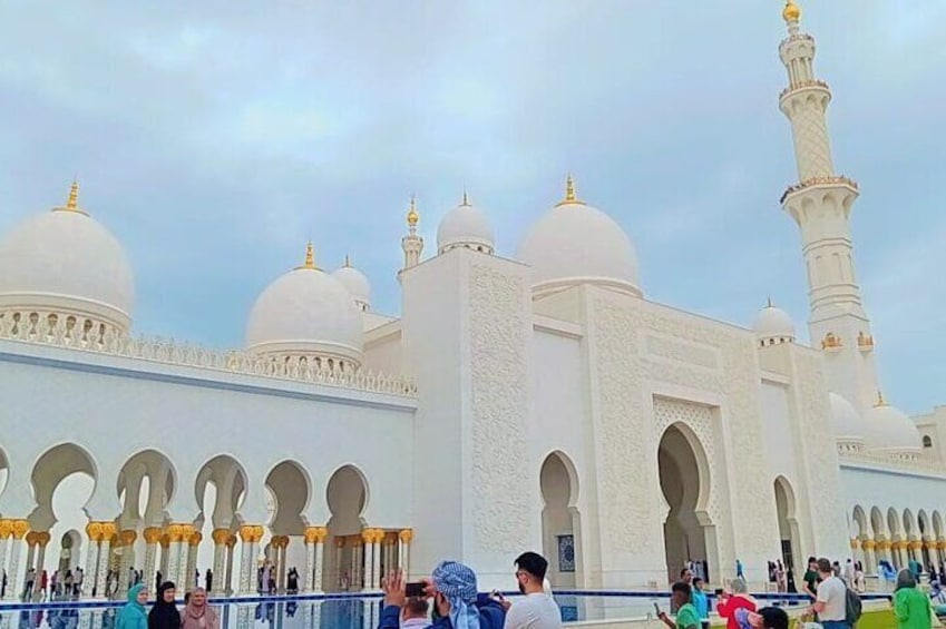 Une grande mosquée blanche, dotée de plusieurs coupoles et d’un haut minaret. 1