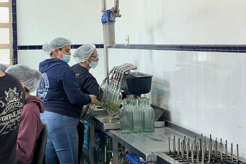 Una cucina con tre persone che indossano berretti da chef, un lavandino e un'area dedicata alla preparazione del cibo. 4