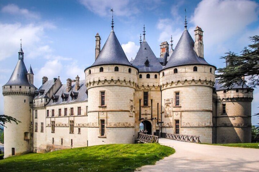 A castle with multiple towers and a well-maintained lawn. 1