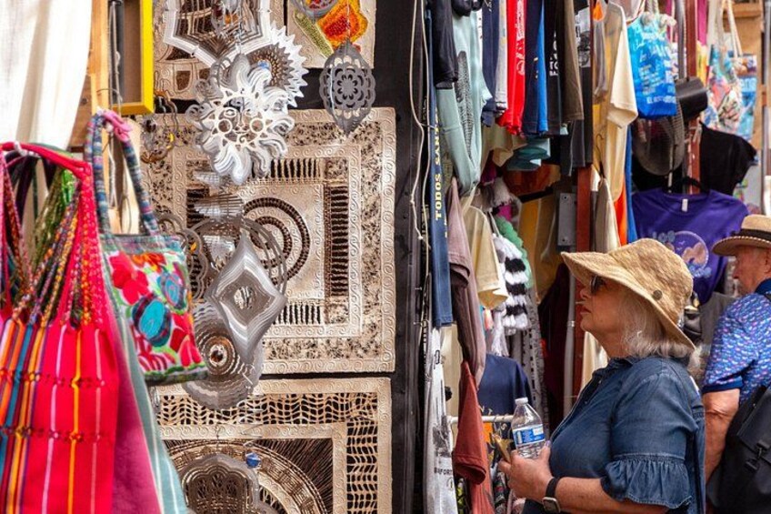 A market stall with various items including bags, clothing, and decorative objects. 5