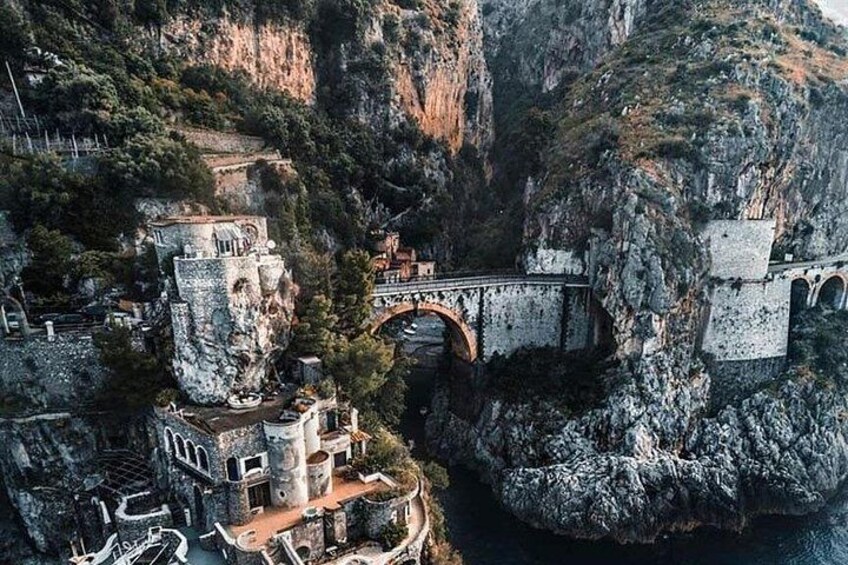 A coastal town with a prominent church, a bridge, and rugged cliffs. 2
