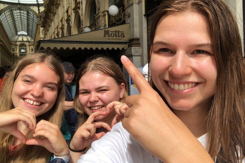 A group of people making a heart shape with their hands. 4