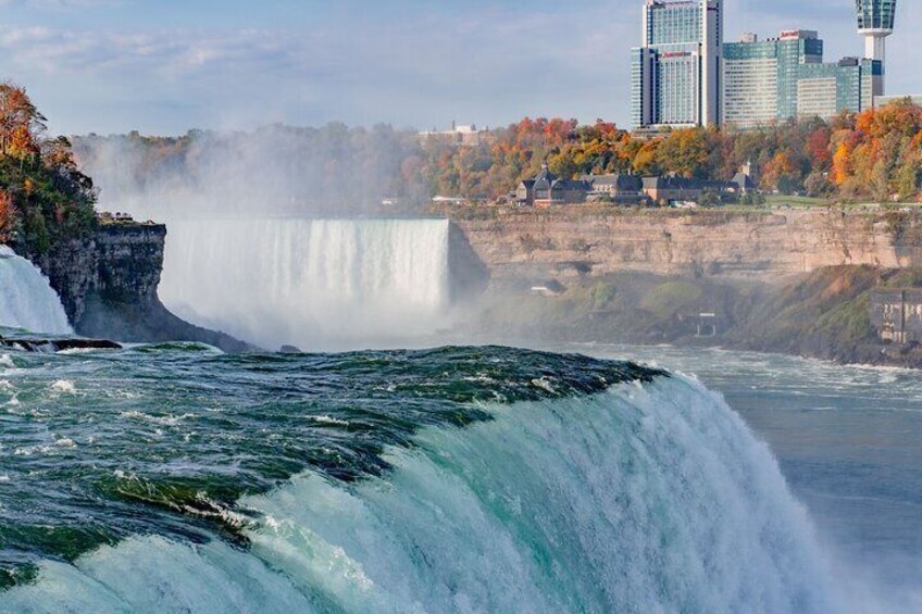 Una cascada grande con un paisaje urbano al fondo. 3