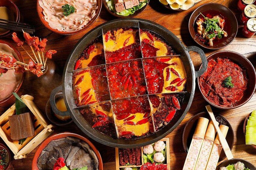 A hot pot with various ingredients and side dishes. 3