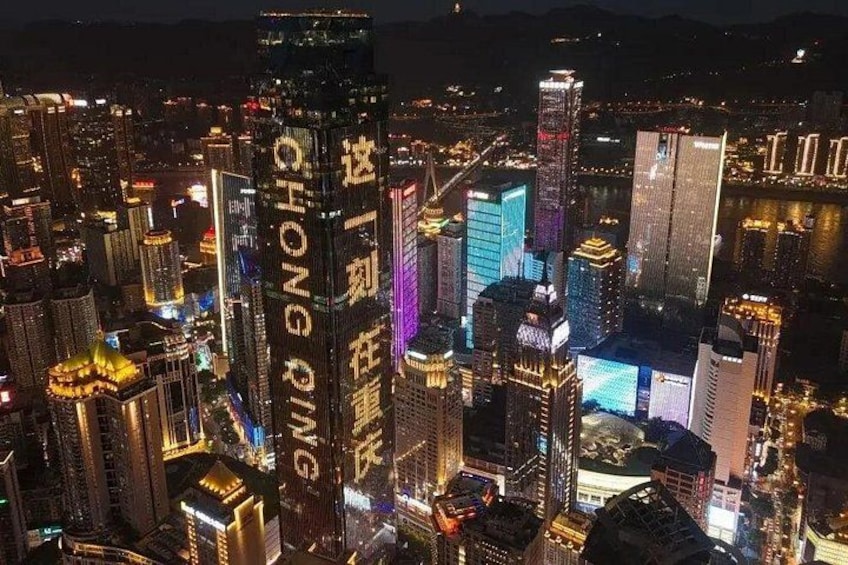 A cityscape at night with illuminated buildings and a river in the background. 2